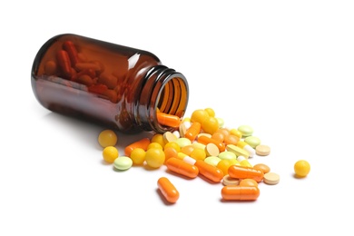 Photo of Bottle with vitamin pills and capsules on white background