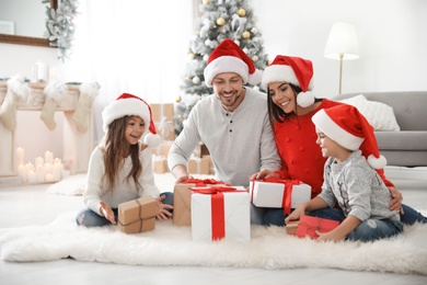 Happy family with children and Christmas gifts on floor at home