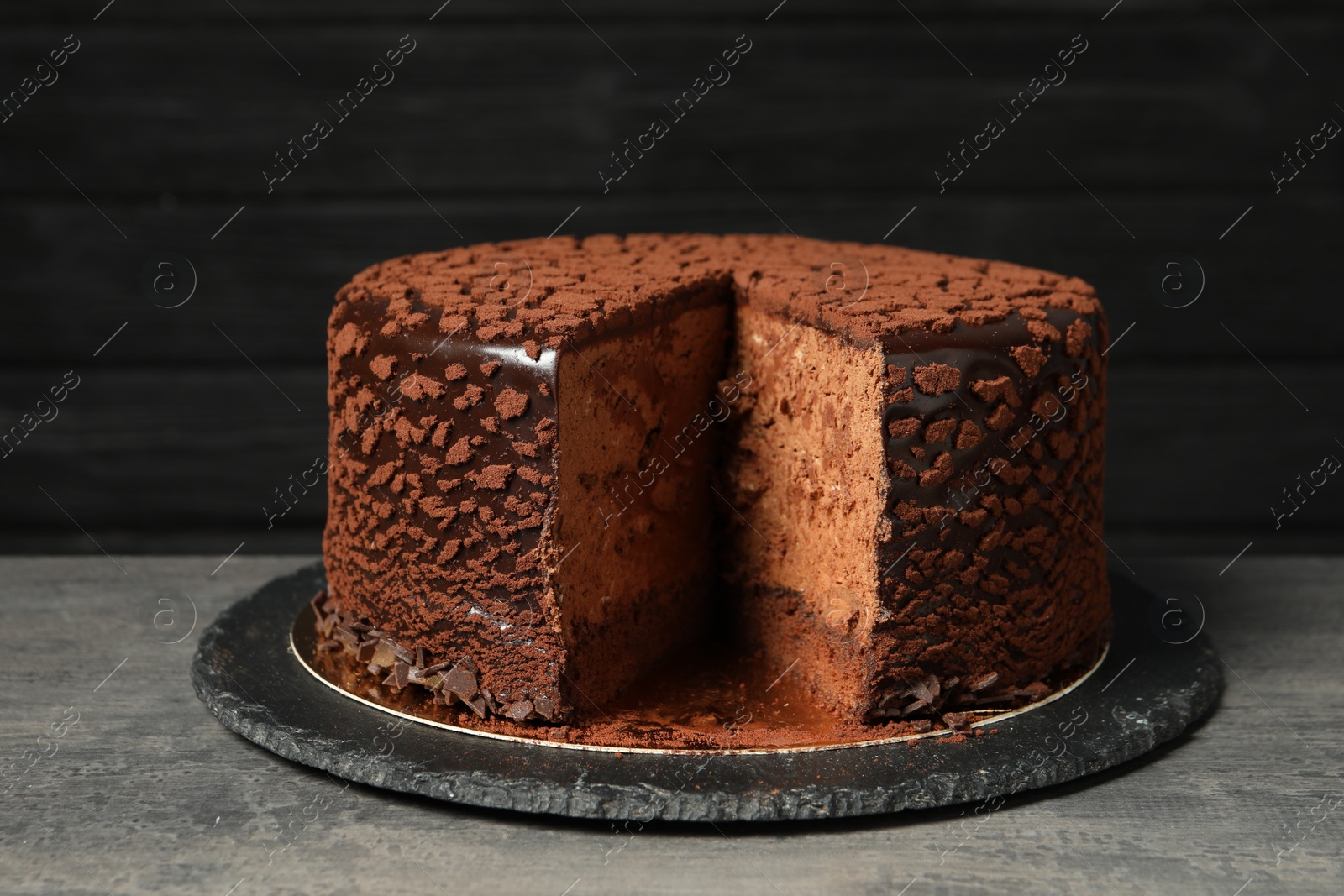 Photo of Delicious chocolate truffle cake on grey textured table