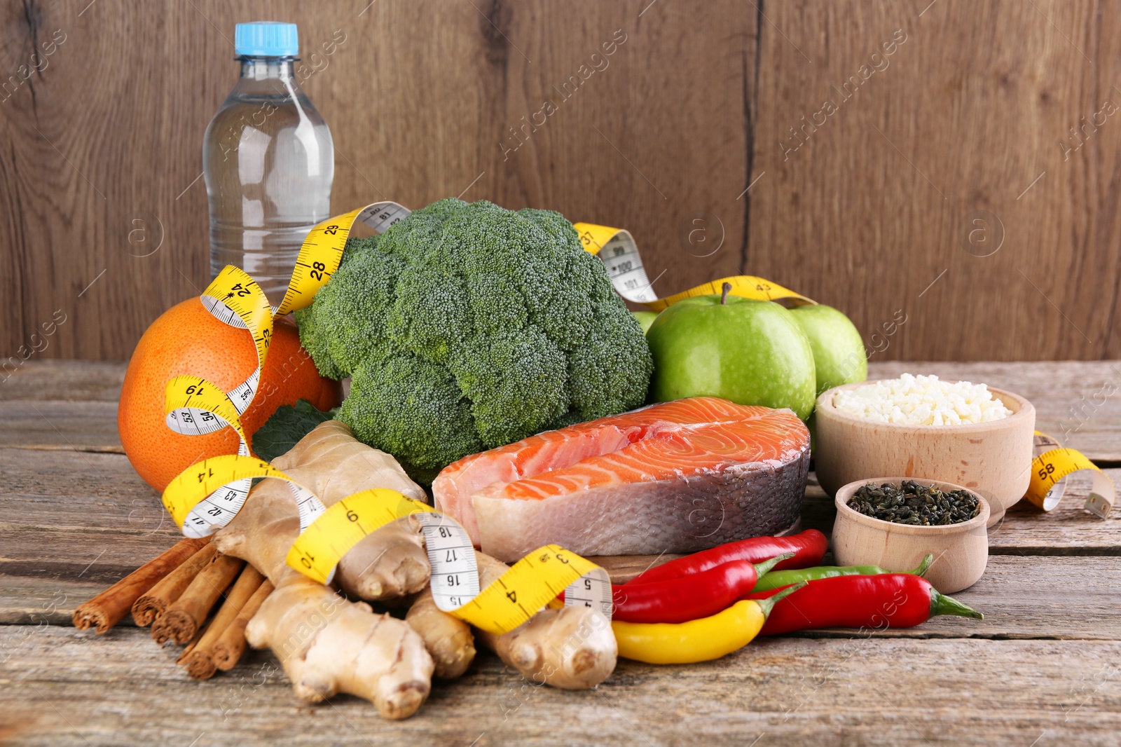 Photo of Metabolism. Different food products and measuring tape on wooden table