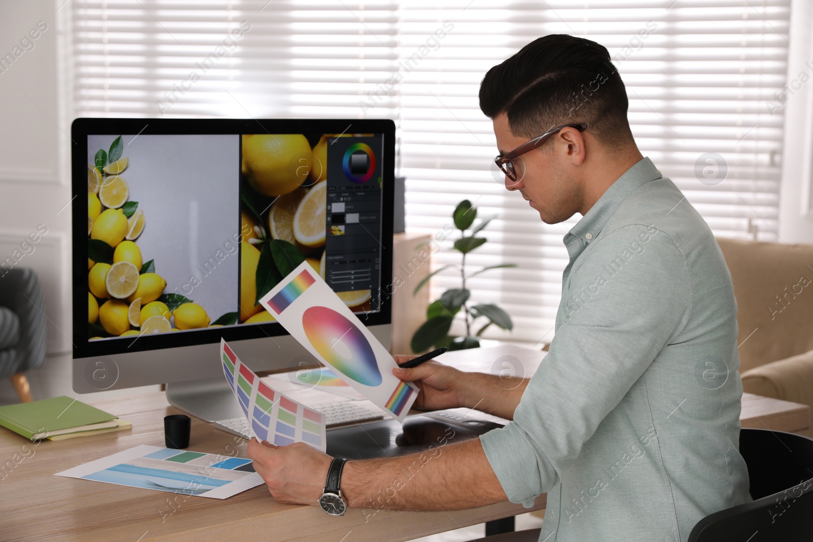 Photo of Professional retoucher working on computer in office