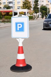 Photo of Traffic cone with road sign Parking place on sunny day outdoors