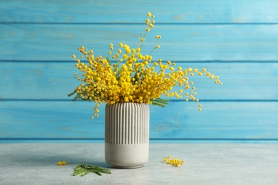 Photo of Bouquet of beautiful mimosa flowers on grey table