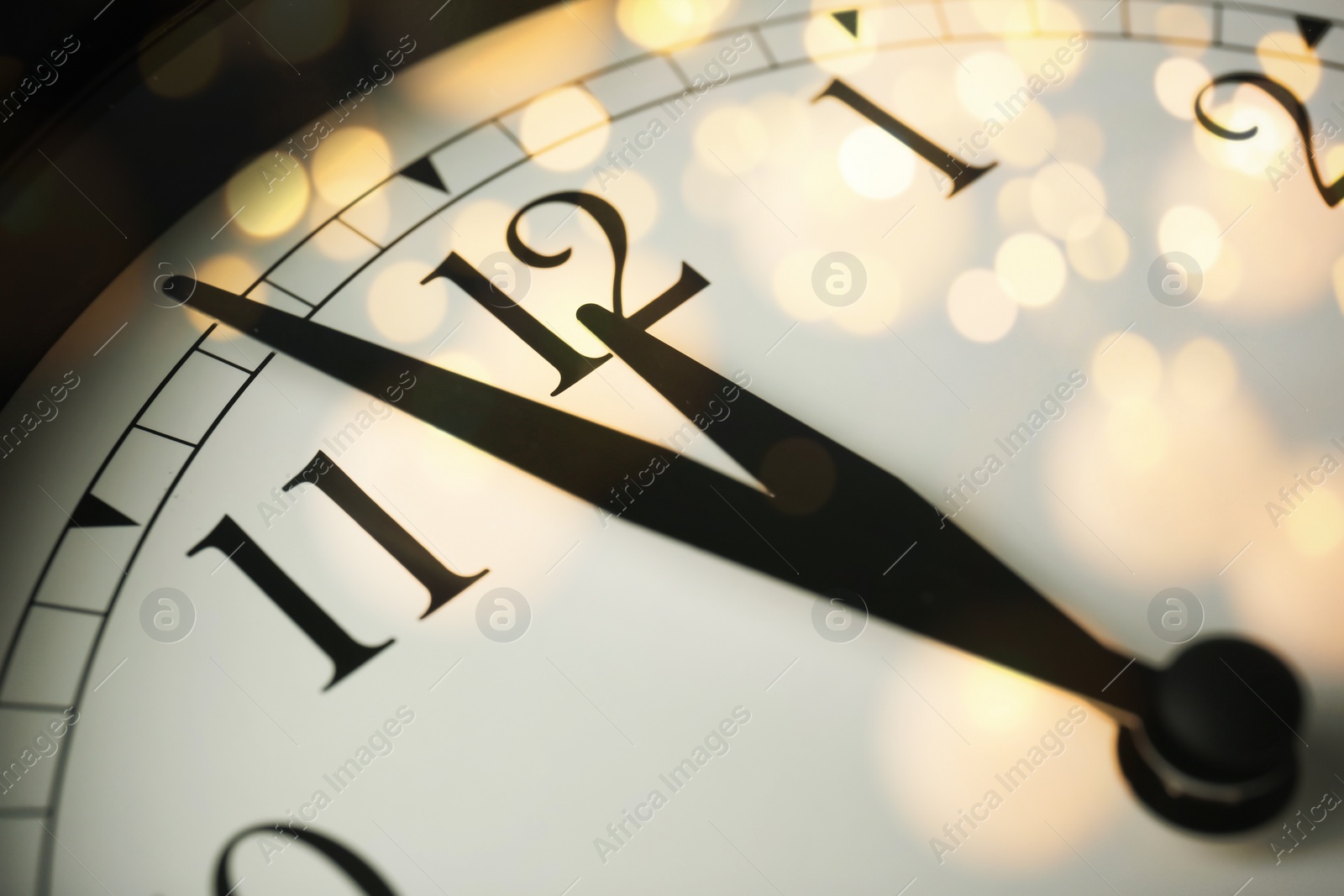 Image of Clock showing five minutes till midnight with bokeh effect, closeup. New Year countdown