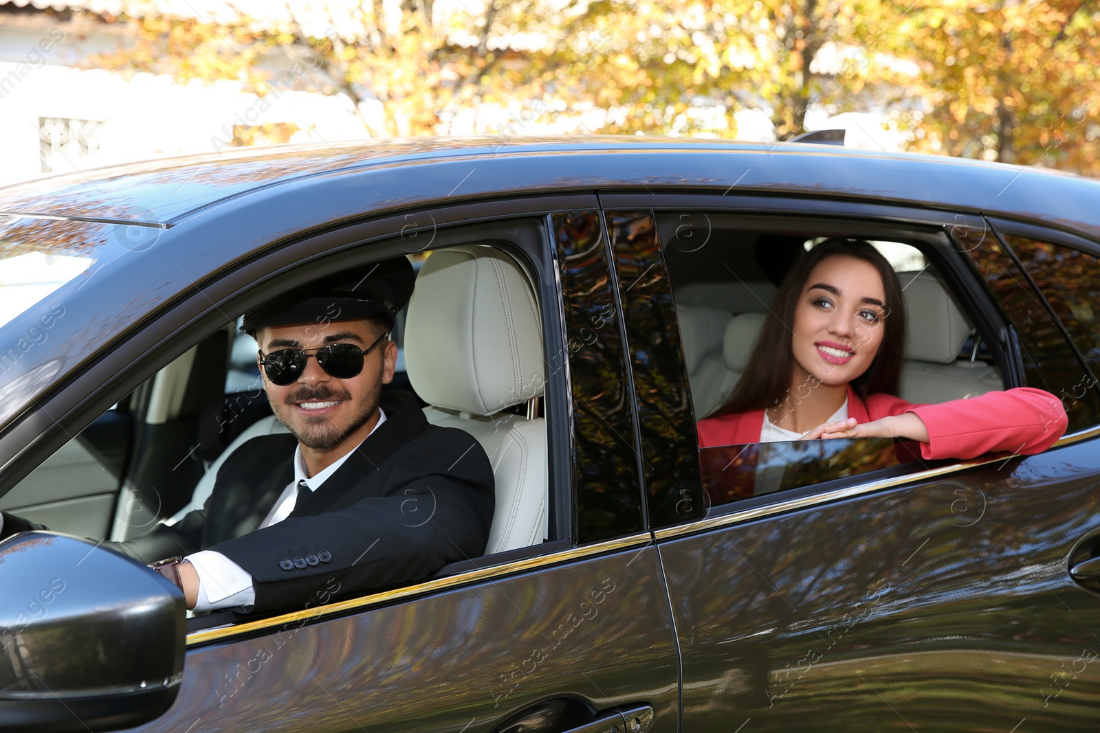 Photo of Young businesswoman with handsome driver in luxury car