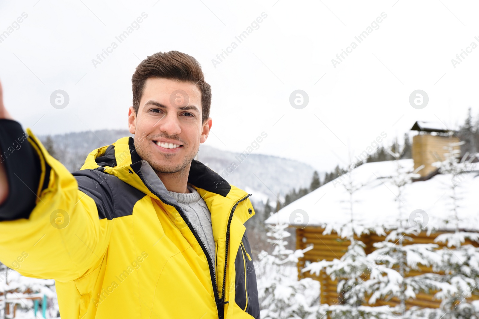 Photo of Happy man taking selfie at resort. Winter vacation