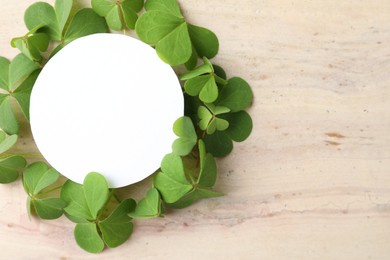 Photo of Frame of clover leaves and blank card on light table, flat lay with space for text. St. Patrick's Day celebration
