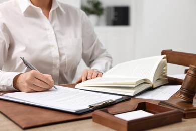 Photo of Lawyer working with documents at wooden table in office, closeup