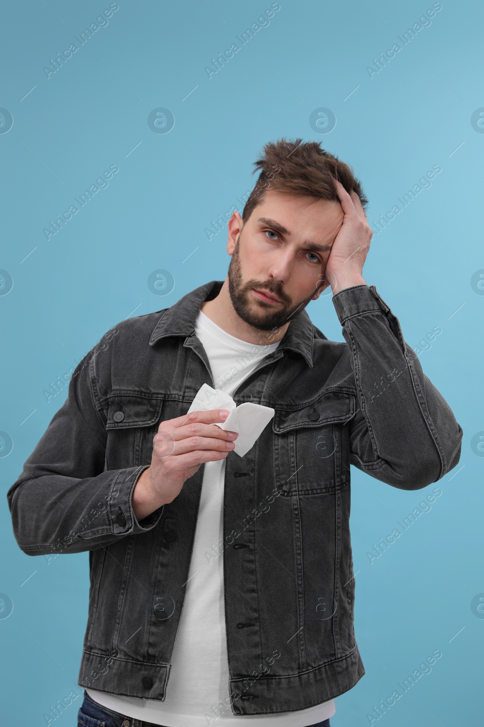 Photo of Man suffering from cold on light blue background