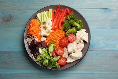 Balanced diet and healthy foods. Plate with different delicious products on blue wooden table, top view