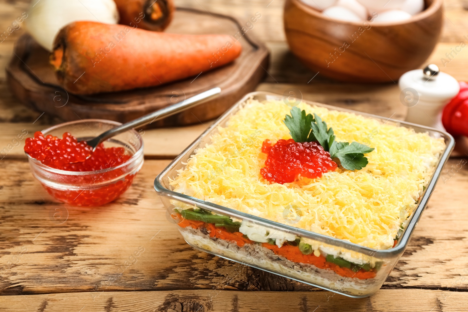 Photo of Traditional russian salad Mimosa served on wooden table