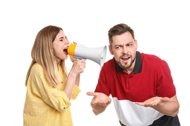 Young woman with megaphone shouting at man on white background