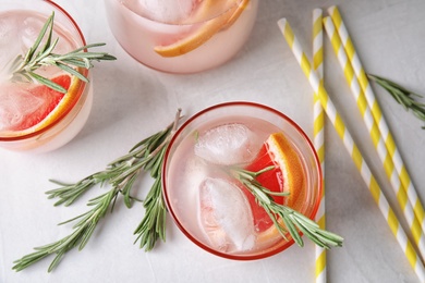 Photo of Flat lay composition with grapefruit cocktail and rosemary on gray table