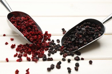 Dried red and black currant berries on white wooden table