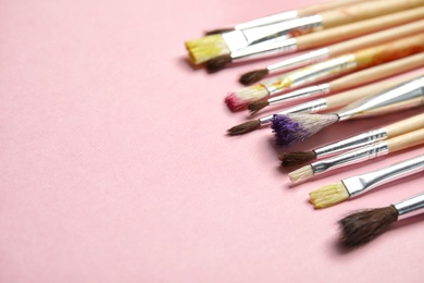 Photo of Different paint brushes on color background. Space for text