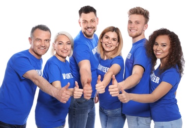 Team of volunteers in uniform showing thumbs up on white background