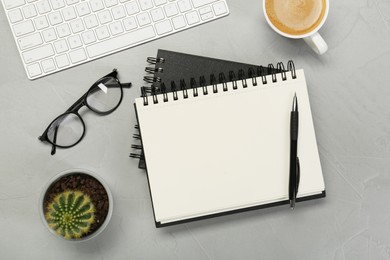 Photo of Flat lay composition with notebooks, glasses and coffee on light grey table