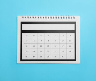 Paper calendar on light blue background, top view