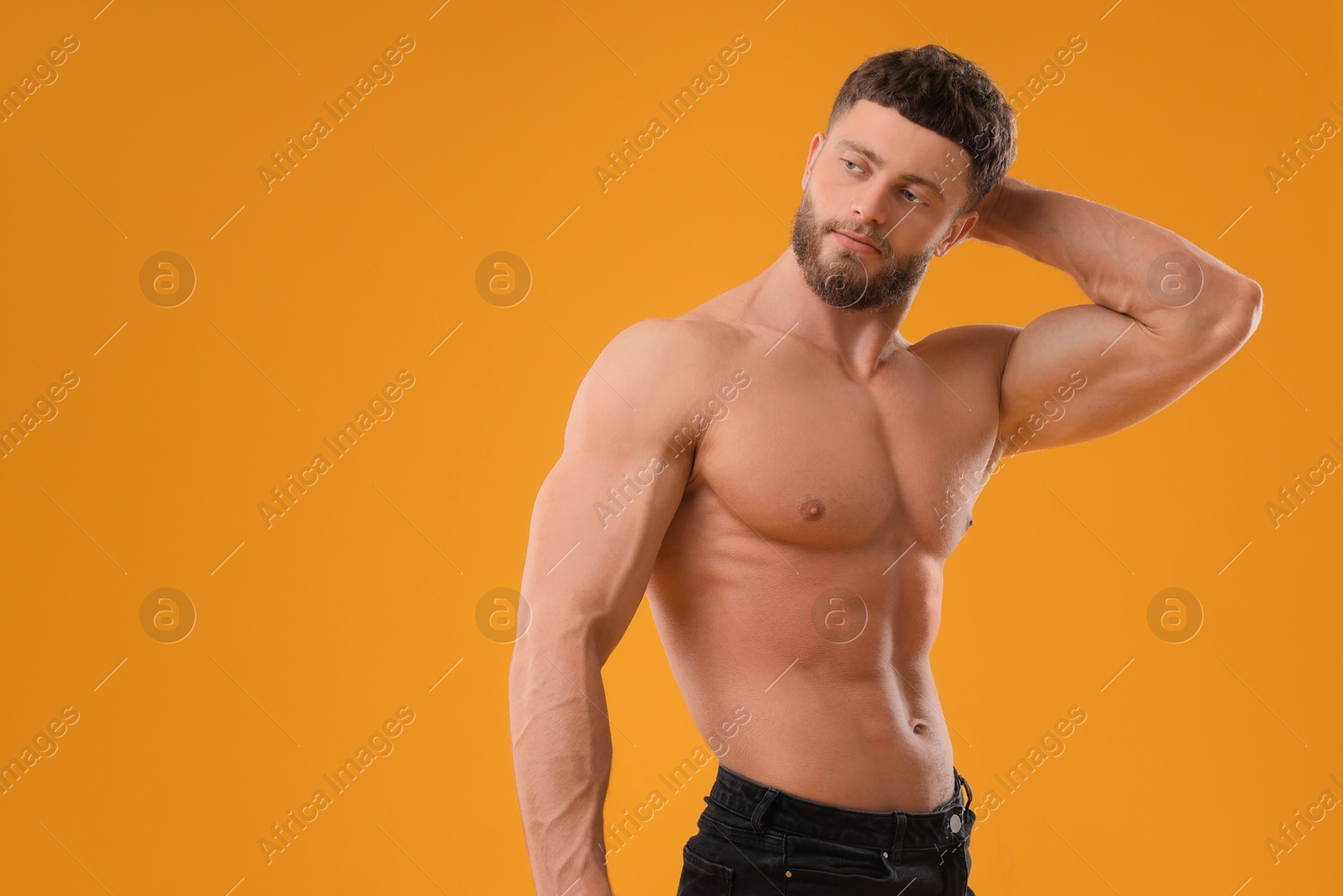 Photo of Handsome muscular man on orange background, space for text. Sexy body