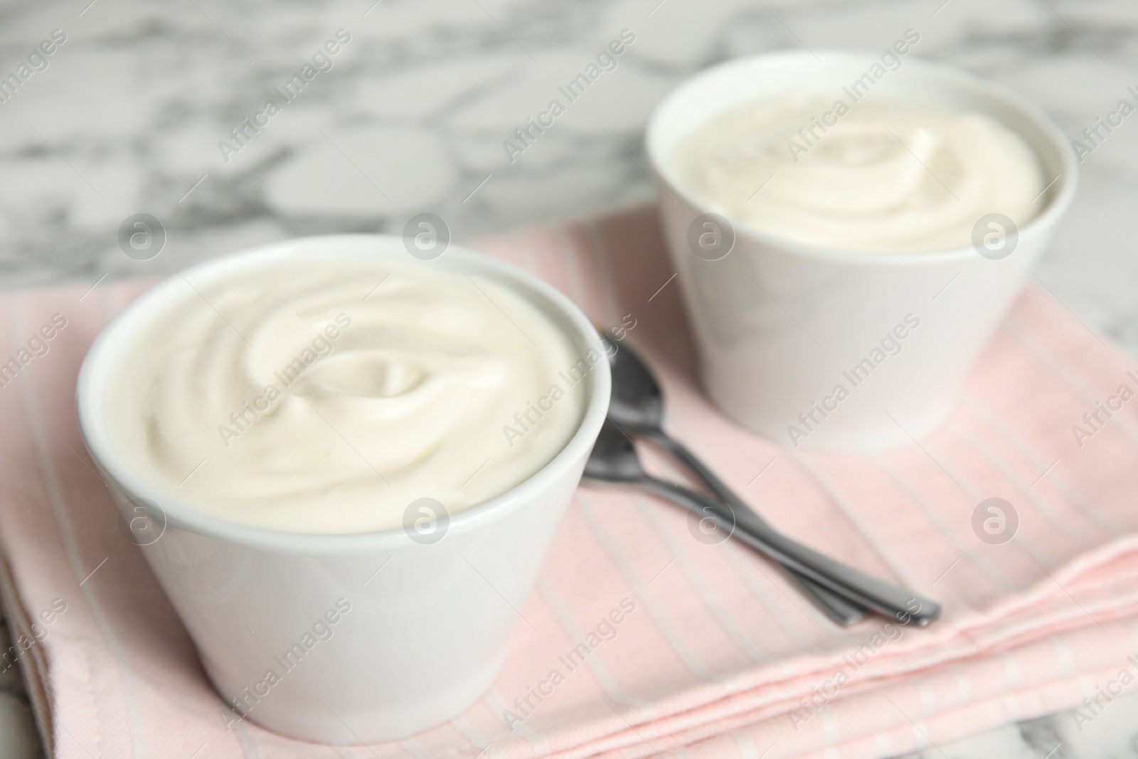 Photo of Tasty organic yogurt on white marble table. Space for text