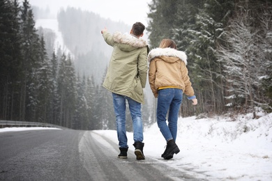 Photo of Couple walking near snowy forest. Winter vacation