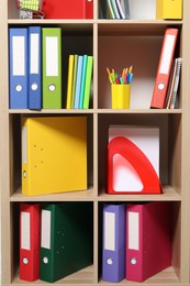 Colorful binder office folders and other stationery on shelving unit