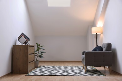 Photo of Attic room interior with slanted ceiling and furniture