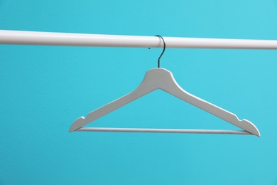 Photo of Wardrobe rack with hanger on color background