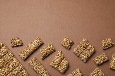 Photo of Pieces of delicious kozinaki bars on brown background, flat lay. Space for text