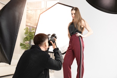 Photo of Beautiful young model posing for professional photographer in studio