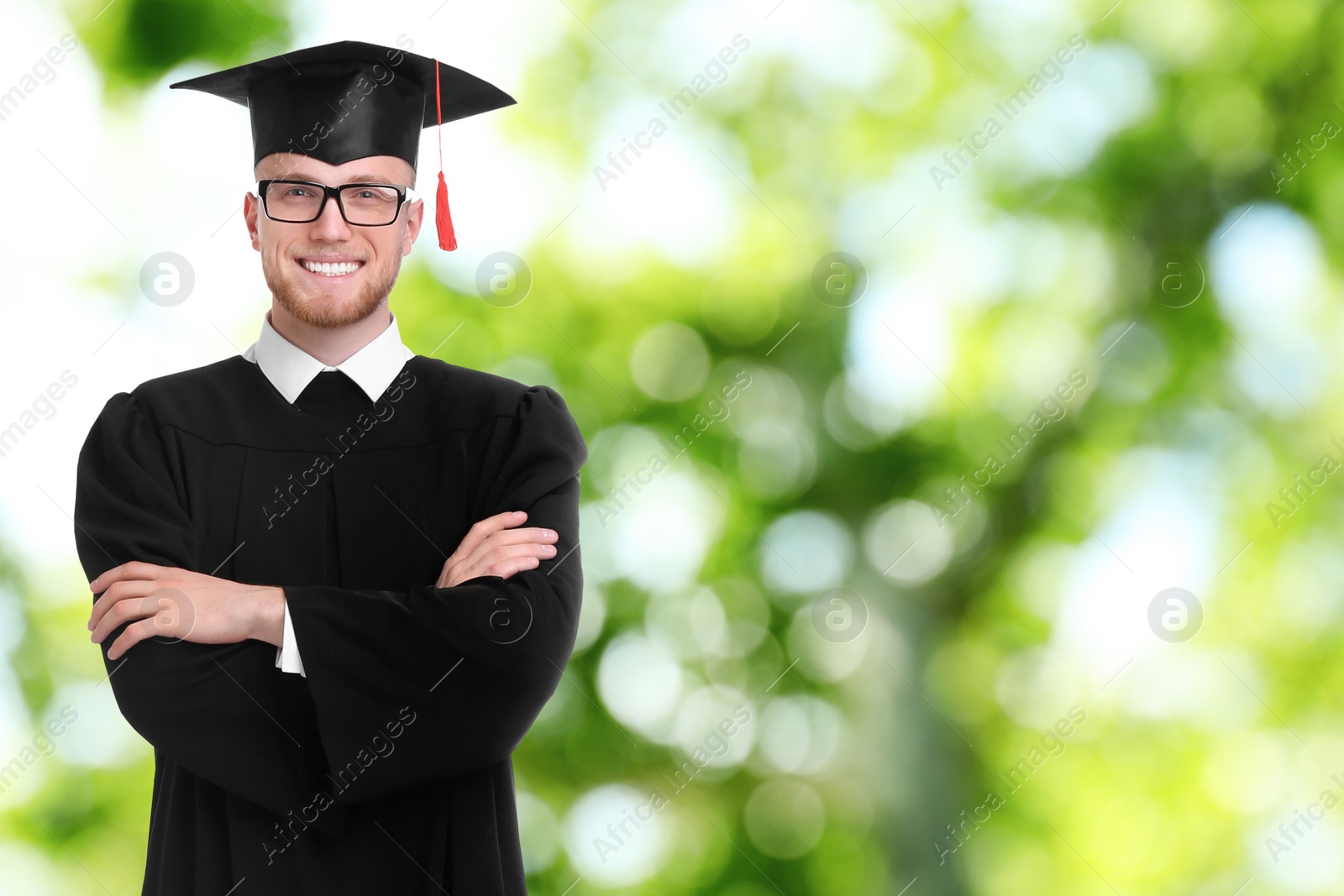 Image of Happy student wearing graduation hat on blurred background, space for text