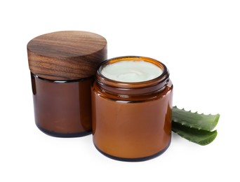 Jars of hand cream and aloe on white background