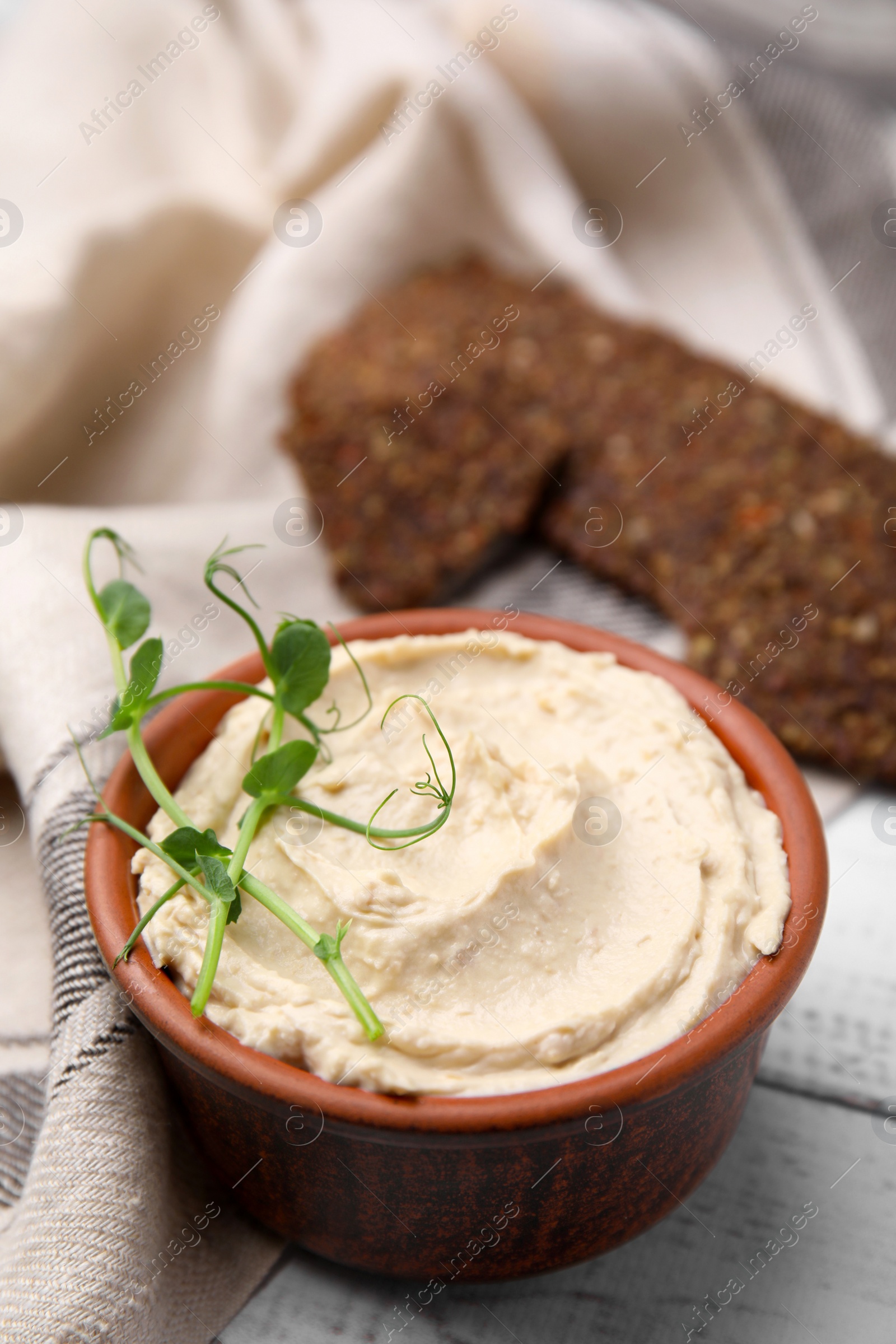 Photo of Delicious hummus served on white wooden table