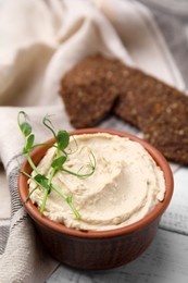 Photo of Delicious hummus served on white wooden table