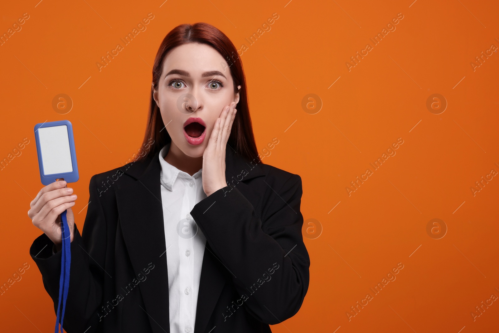 Photo of Shocked woman with vip pass badge on orange background. Space for text