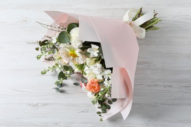 Bouquet of beautiful flowers on white wooden table, above view