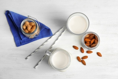 Photo of Almond and peanut milk with nuts on wooden background