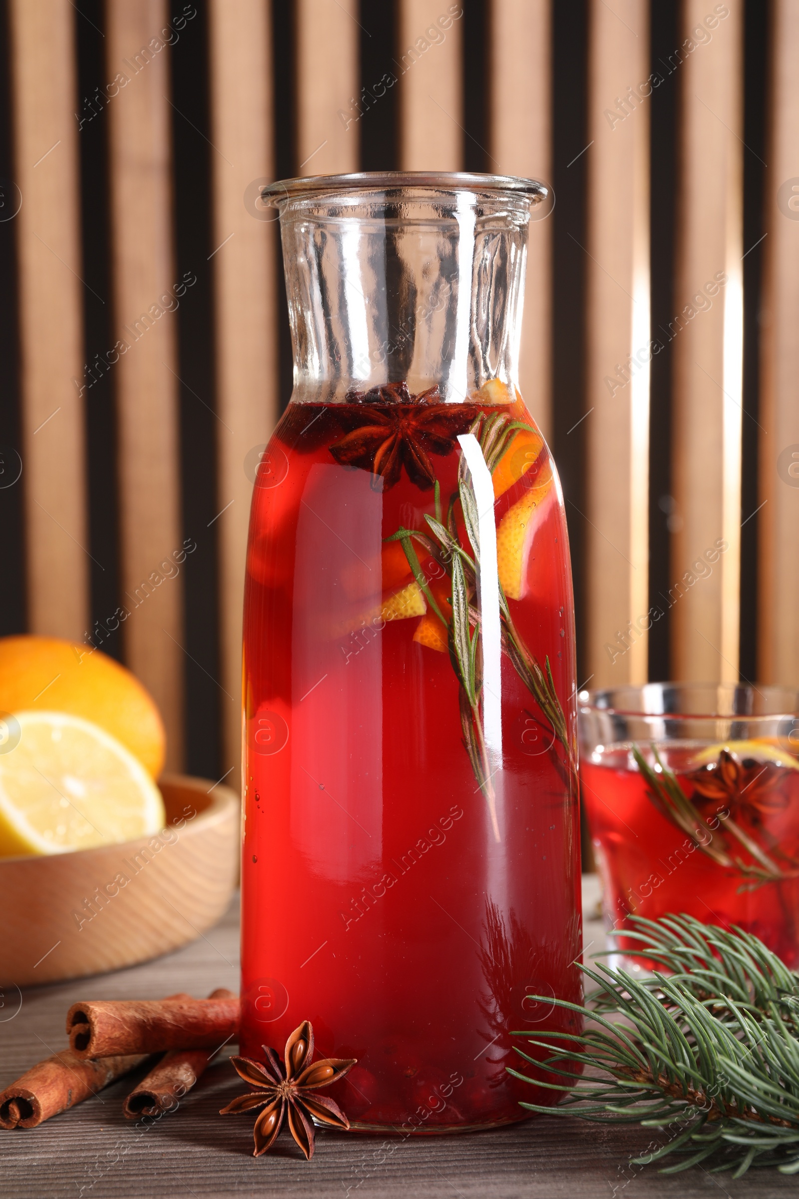 Photo of Aromatic punch drink and ingredients on wooden table