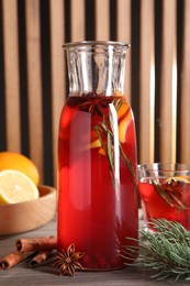 Photo of Aromatic punch drink and ingredients on wooden table