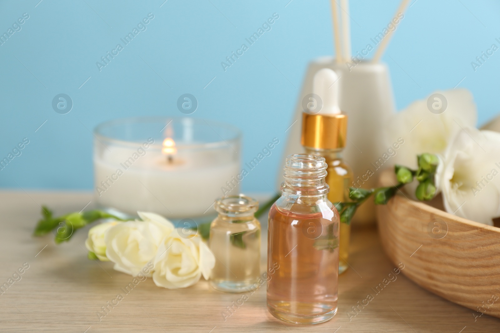 Photo of Beautiful spa composition with essential oil and candle on wooden table