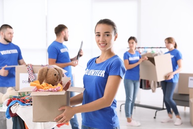 Photo of Female volunteer holding box with donations indoors