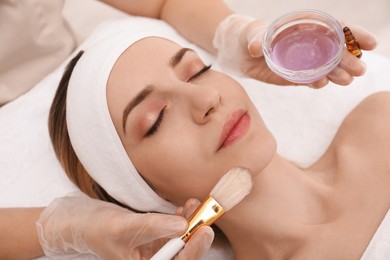 Young woman during face peeling procedure in salon