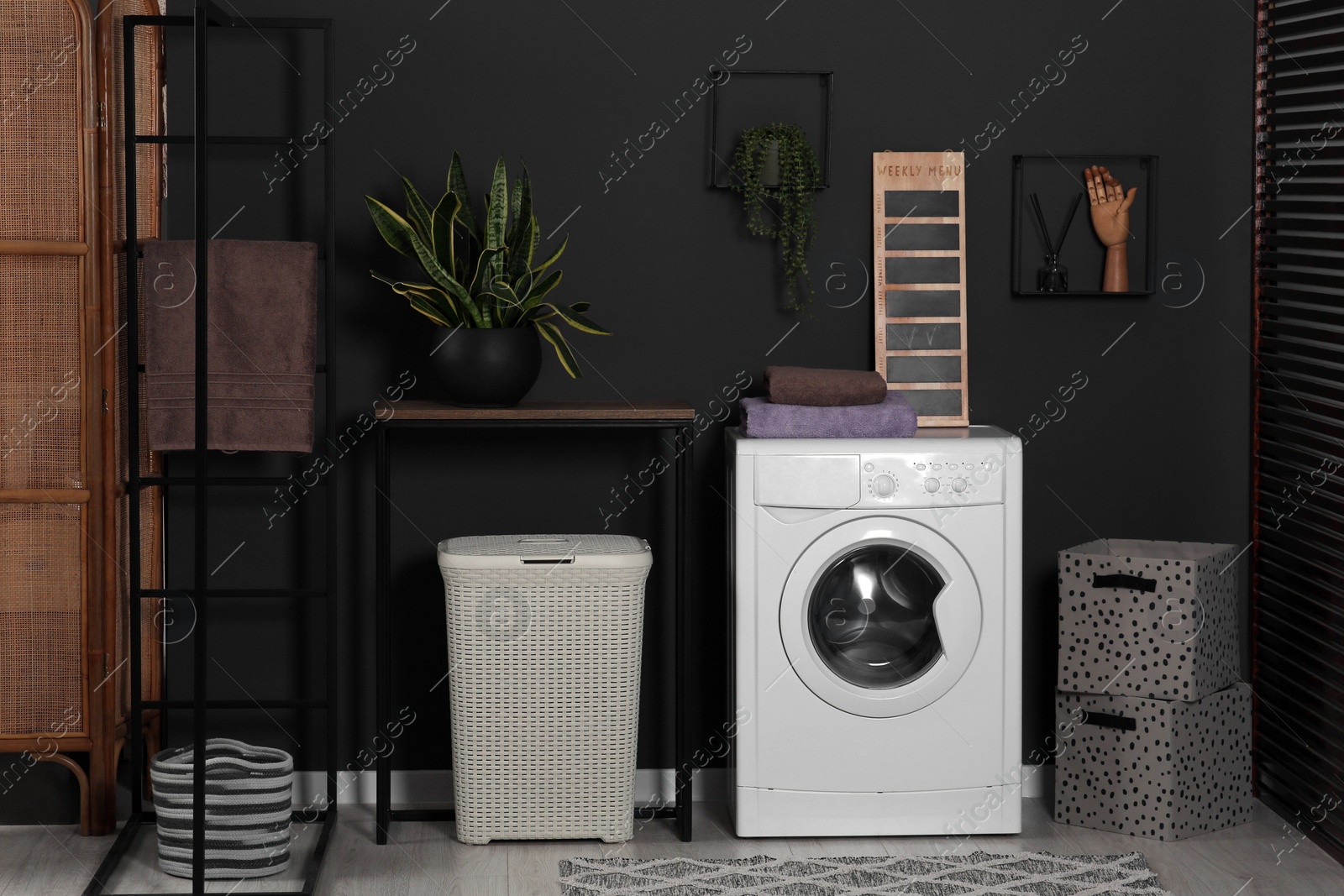 Photo of Stylish laundry room with washing machine. Interior design