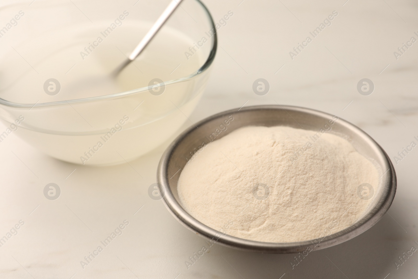 Photo of Agar-agar jelly and powder on white table, closeup