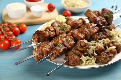 Photo of Metal skewers with delicious meat and vegetables served on light blue wooden table, closeup