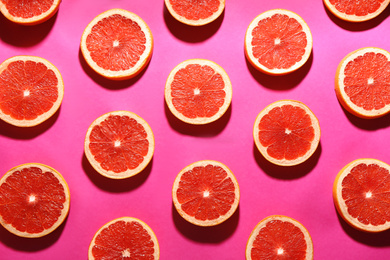 Photo of Flat lay composition with tasty ripe grapefruit slices on magenta background