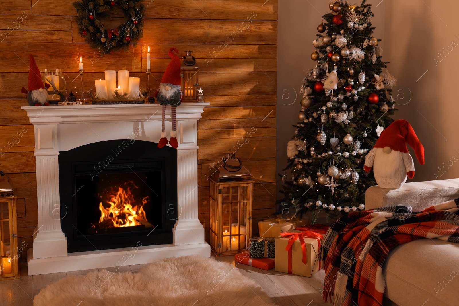 Photo of Cute gnomes and Christmas tree in room with festive decorations