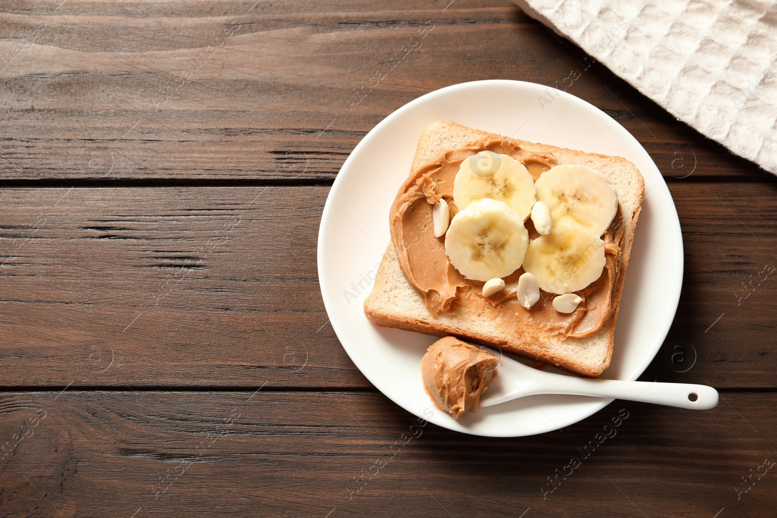 Photo of Toast bread with peanut butter and banana slices on wooden table