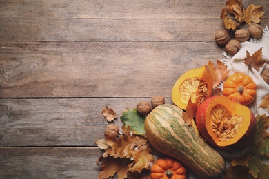 Photo of Flat lay composition with vegetables, nuts and autumn leaves on wooden table, space for text. Thanksgiving Day