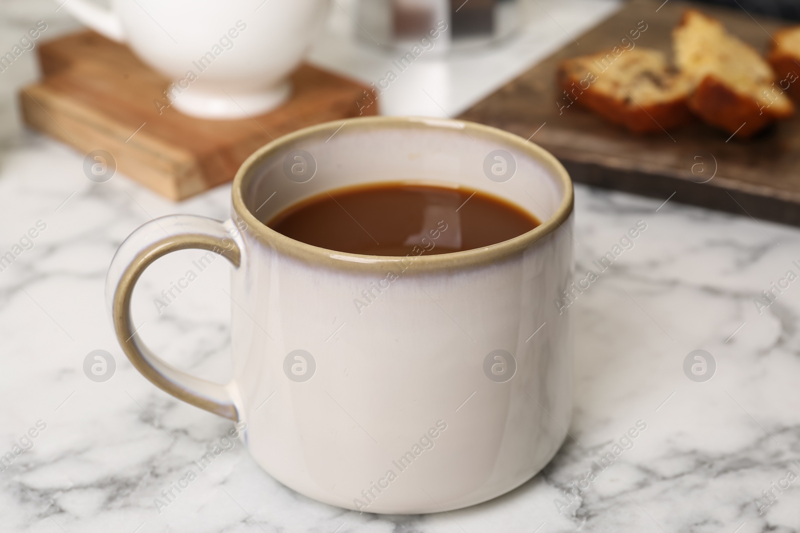 Photo of Cup of fresh aromatic coffee on white marble table